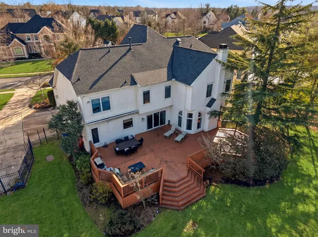 an aerial view of a house with a yard and large tree