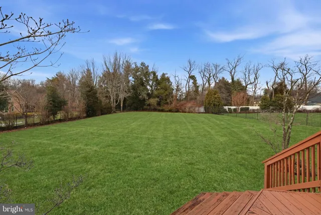 a front view of a house with a garden and trees