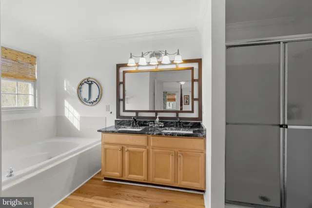 a bathroom with a granite countertop sink mirror and a bathtub