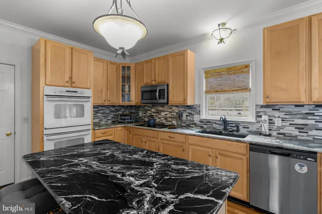 a kitchen with granite countertop a stove and a sink