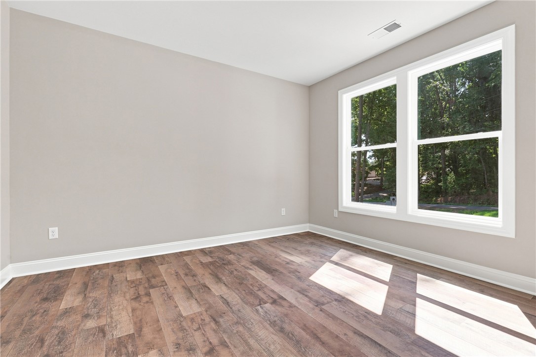 216 West Halfway Branch Road Walhalla, SC 29691 - Photo 19 of 41 Rich wood-look flooring and crisp white trim frame views of the surrounding mature trees.