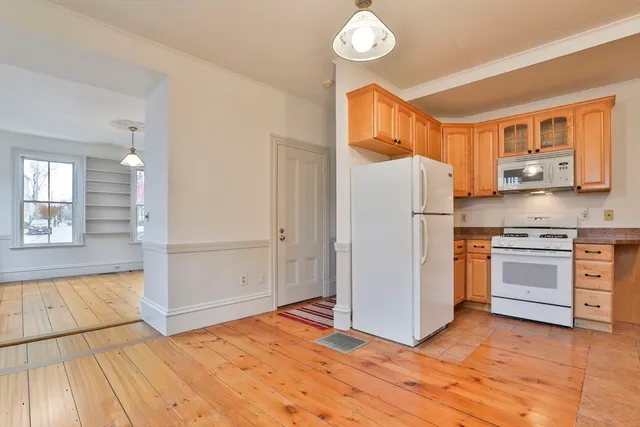 a kitchen with a refrigerator and white cabinets