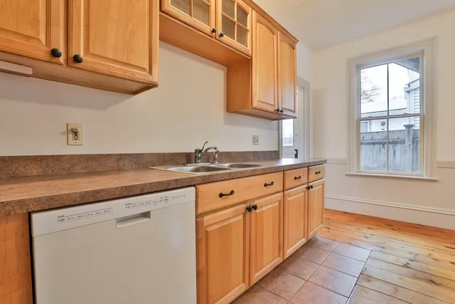a kitchen with stainless steel appliances granite countertop a sink and dishwasher with wooden cabinets