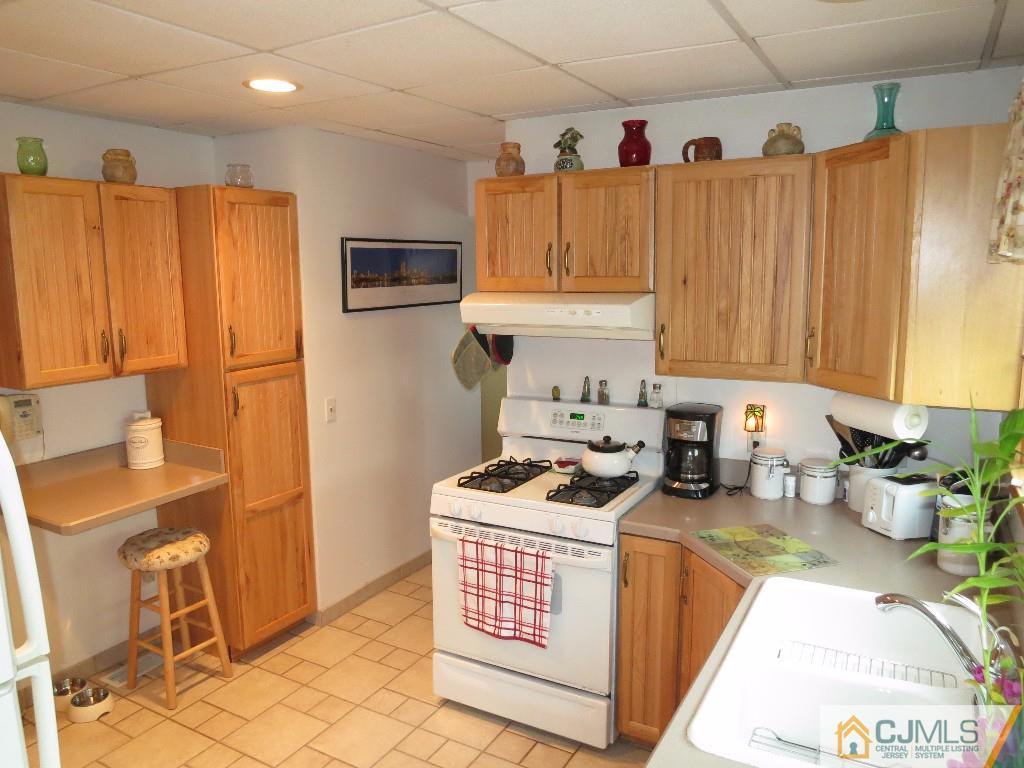 126 New Market Road Dunellen, NJ 08812 - Photo 14 of 24 a kitchen with stainless steel appliances a stove a sink and a refrigerator