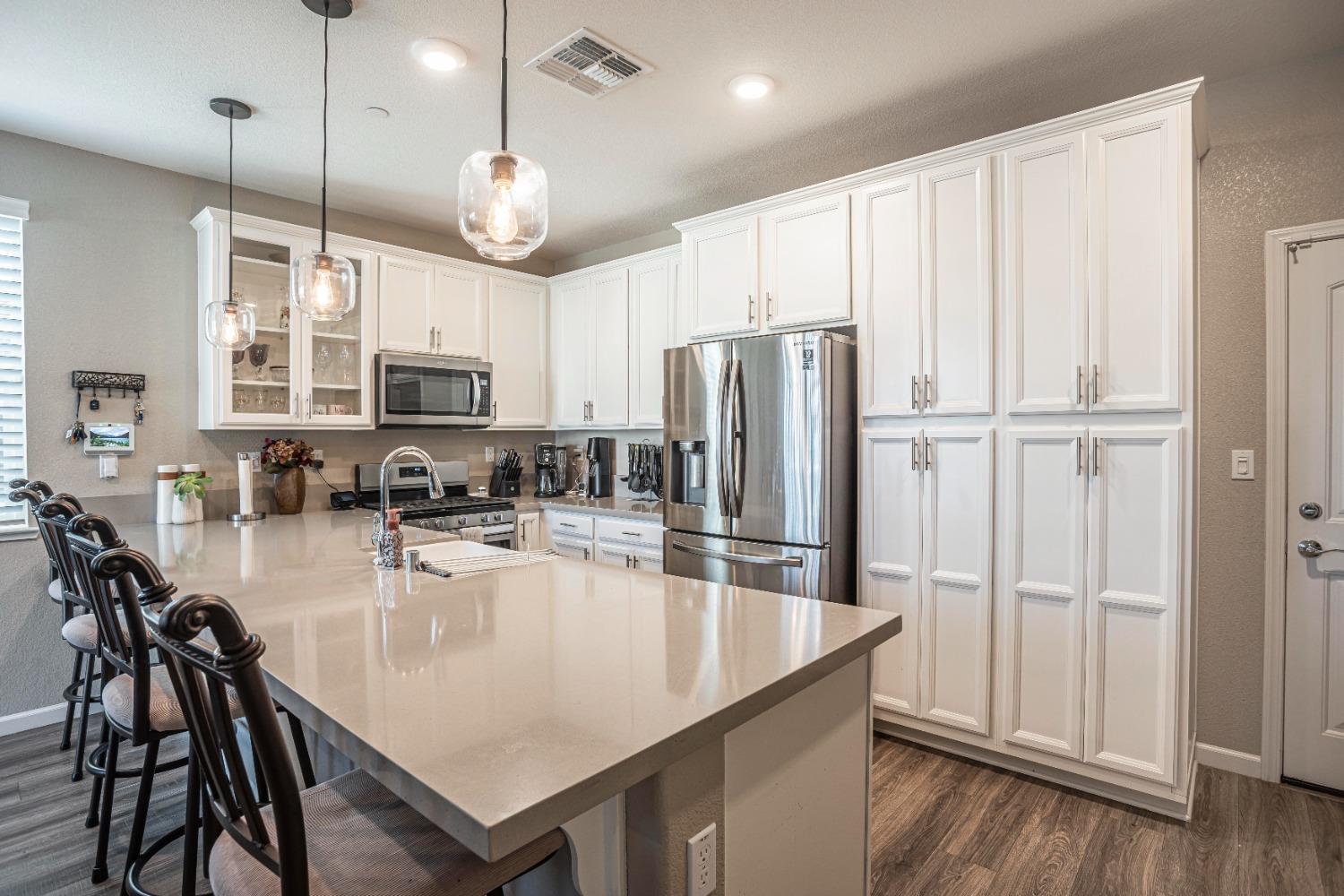 2510 Natomas Crossing Drive Sacramento, CA 95834 - Photo 6 of 34 a kitchen with stainless steel appliances granite countertop a refrigerator a stove a sink a dining table and chairs with wooden floor