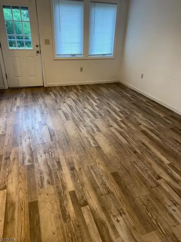 a view of a room with wooden floor and window