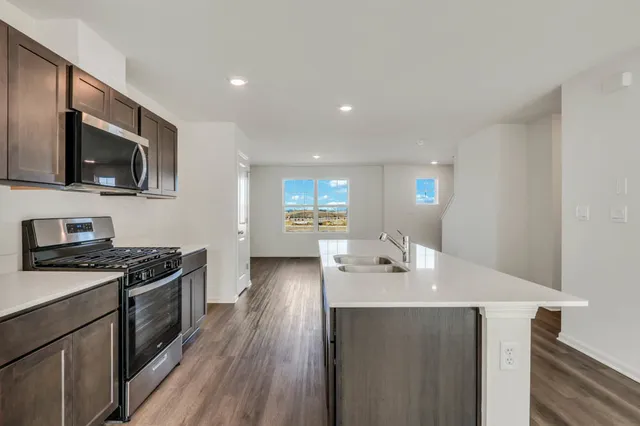 a kitchen with a sink a stove and microwave