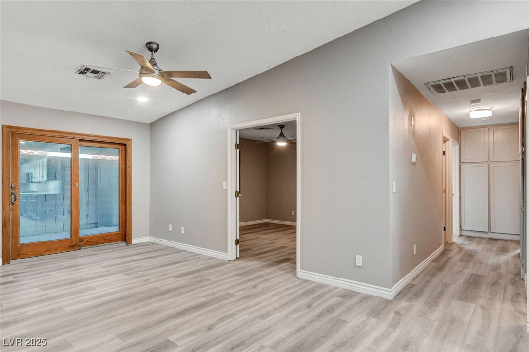 1118 Olmo Way Boulder City, NV 89005 - Photo 11 of 45 Empty room with light wood-style flooring, lofted ceiling, and ceiling fan