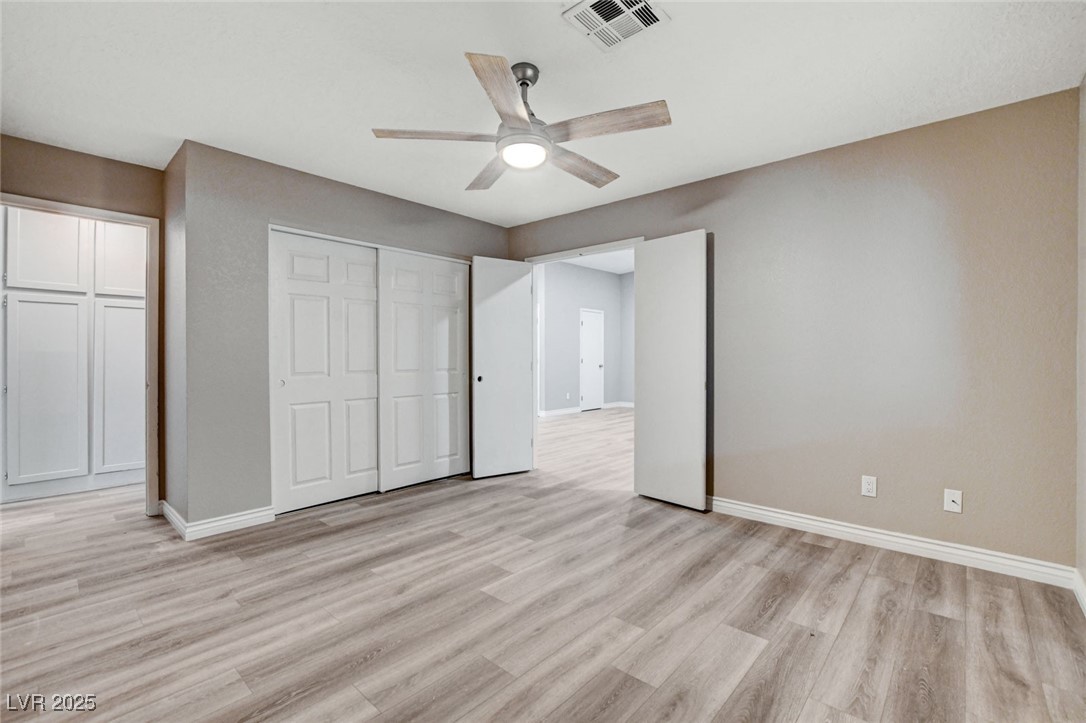 1118 Olmo Way Boulder City, NV 89005 - Photo 15 of 45 Unfurnished bedroom featuring light wood-style flooring, a ceiling fan, and a closet