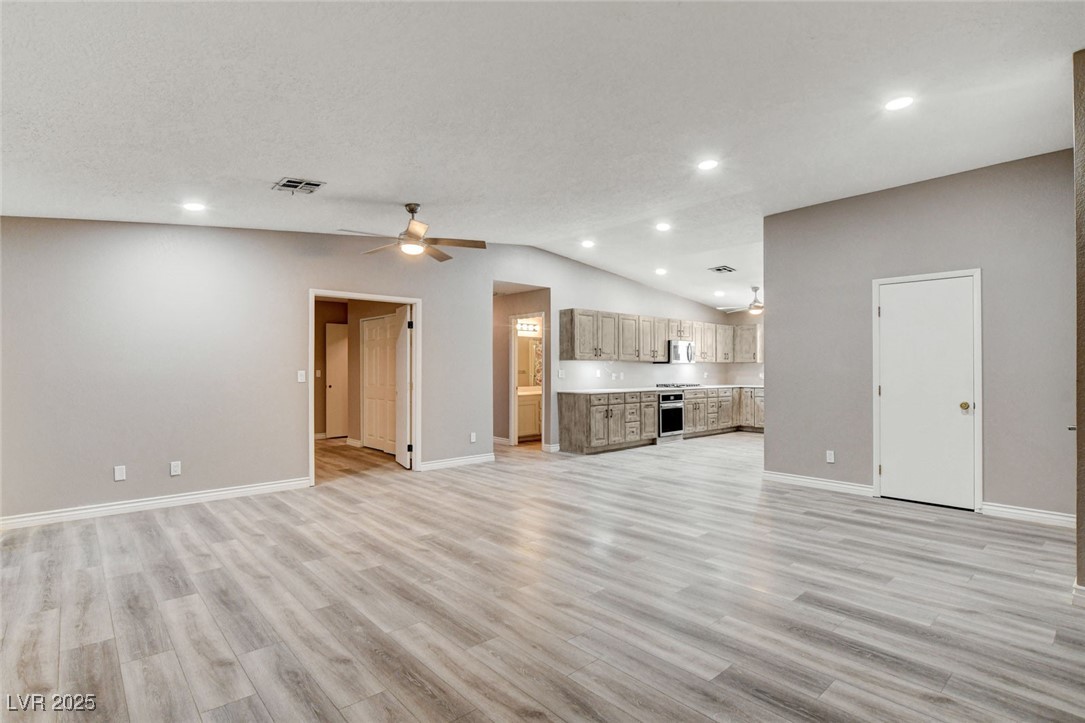1118 Olmo Way Boulder City, NV 89005 - Photo 2 of 45 Unfurnished living room featuring vaulted ceiling, light wood finished floors, recessed lighting, and ceiling fan