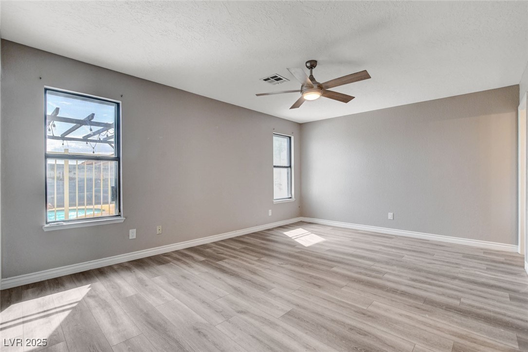 1118 Olmo Way Boulder City, NV 89005 - Photo 22 of 45 Spare room featuring a textured ceiling, light wood-style flooring, and ceiling fan