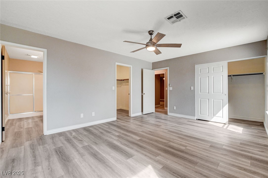 1118 Olmo Way Boulder City, NV 89005 - Photo 24 of 45 Unfurnished bedroom featuring light wood-type flooring, a ceiling fan, and connected bathroom