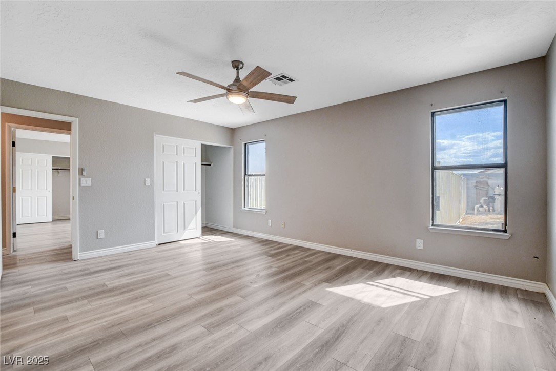 1118 Olmo Way Boulder City, NV 89005 - Photo 25 of 45 Unfurnished bedroom with light wood-style flooring, a ceiling fan, a closet, and a textured ceiling