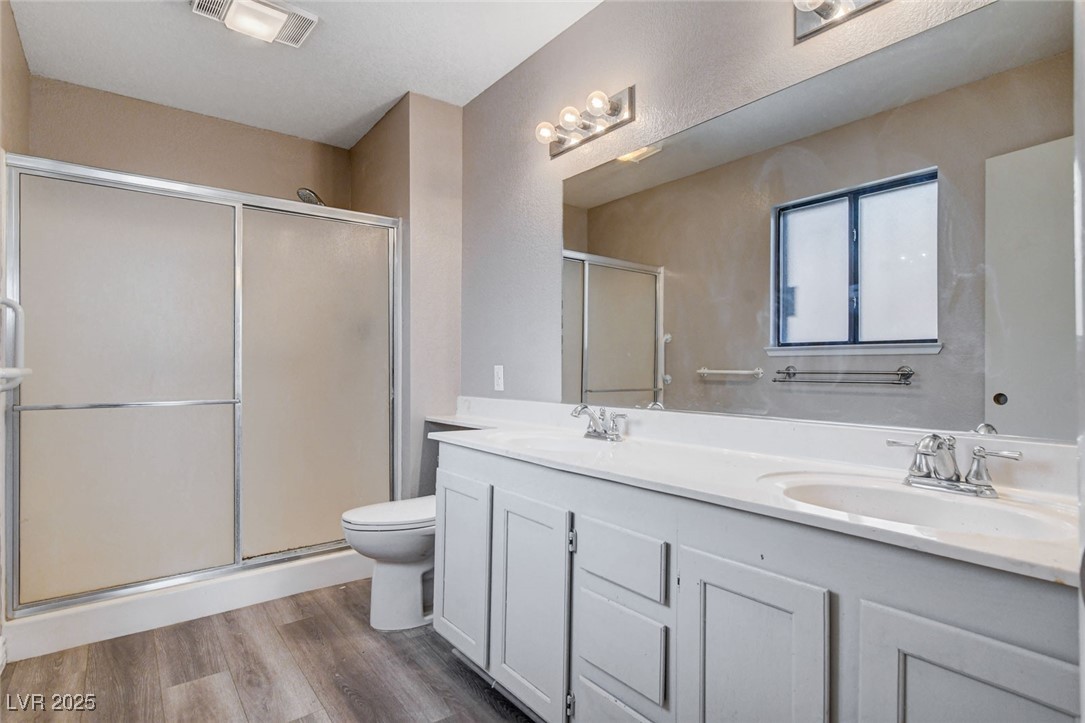1118 Olmo Way Boulder City, NV 89005 - Photo 26 of 45 Bathroom featuring a shower stall, double vanity, and light wood-type flooring