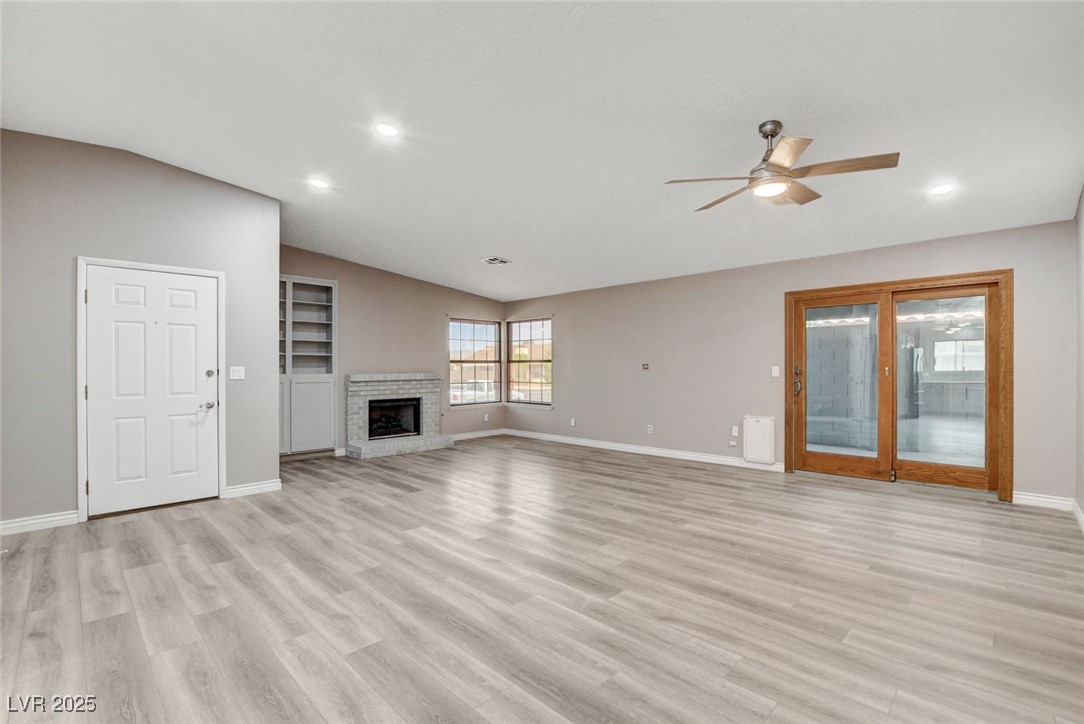 1118 Olmo Way Boulder City, NV 89005 - Photo 4 of 45 Unfurnished living room featuring light wood finished floors, a fireplace, ceiling fan, and recessed lighting