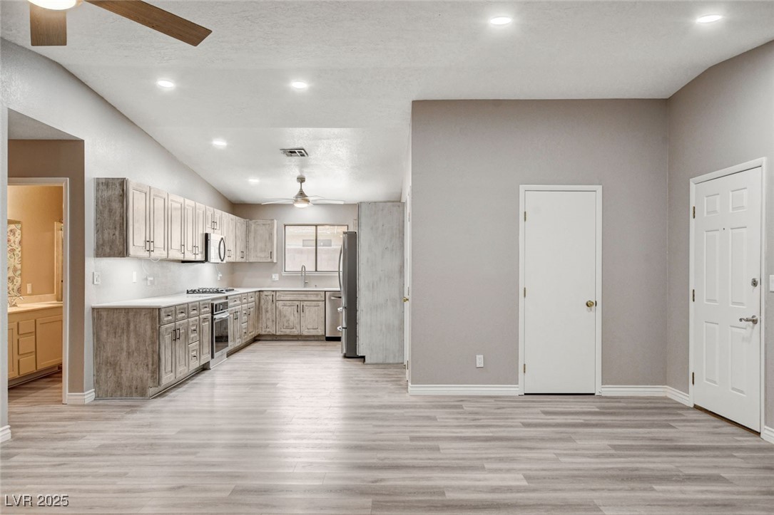 1118 Olmo Way Boulder City, NV 89005 - Photo 6 of 45 Kitchen featuring ceiling fan, light countertops, recessed lighting, lofted ceiling, and light wood-style flooring