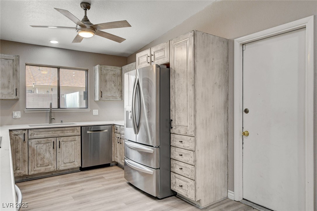 1118 Olmo Way Boulder City, NV 89005 - Photo 9 of 45 Kitchen with stainless steel appliances, light brown cabinetry, light wood-style flooring, a ceiling fan, and vaulted ceiling