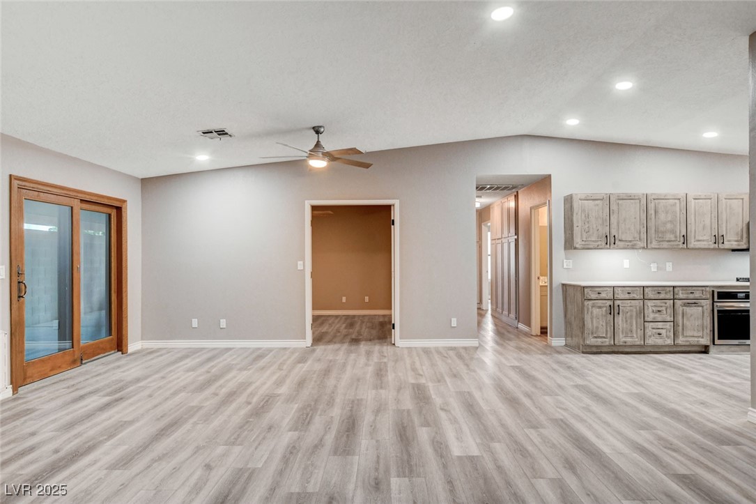 1118 Olmo Way Boulder City, NV 89005 - Photo 10 of 45 Unfurnished living room with light wood-style flooring, lofted ceiling, recessed lighting, and a ceiling fan