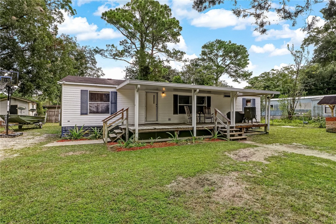 86064 Jones Road Yulee, FL 32097 - Photo 1 of 25 a view of a house with backyard sitting area and garden