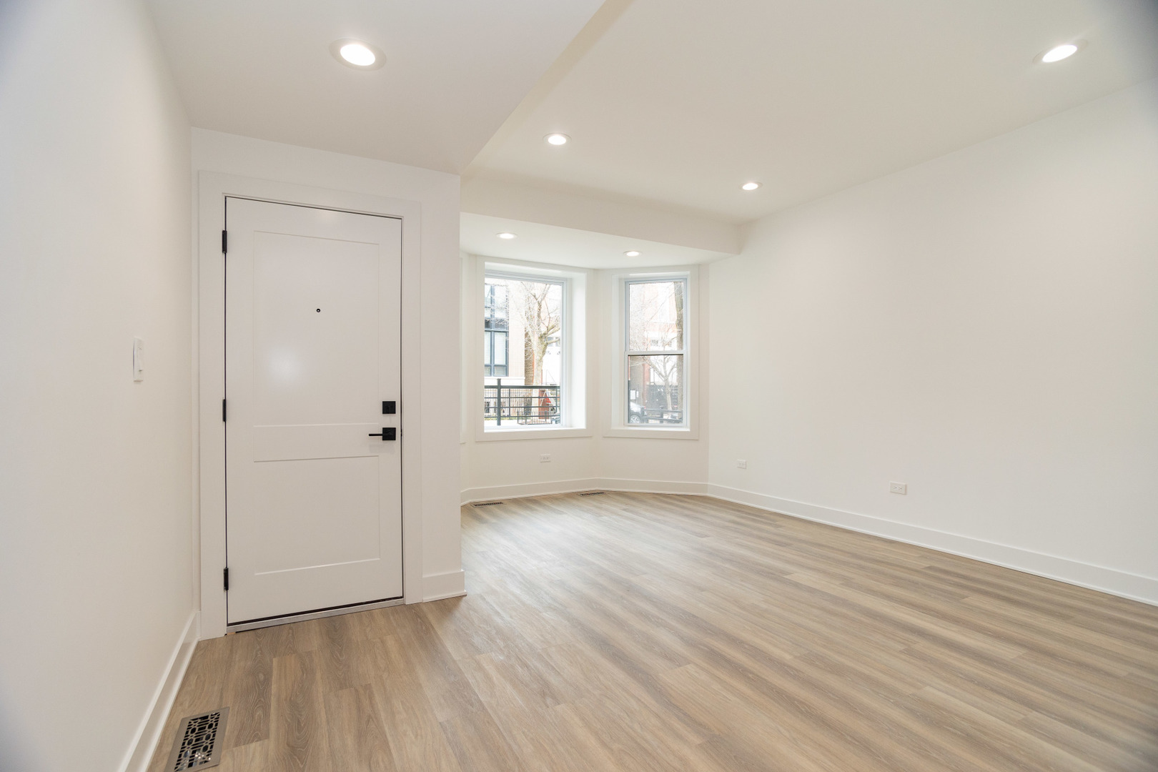 1723 West Pierce Avenue, Unit 1 Chicago, IL 60622 - Photo 3 of 24 an empty room with wooden floor and windows