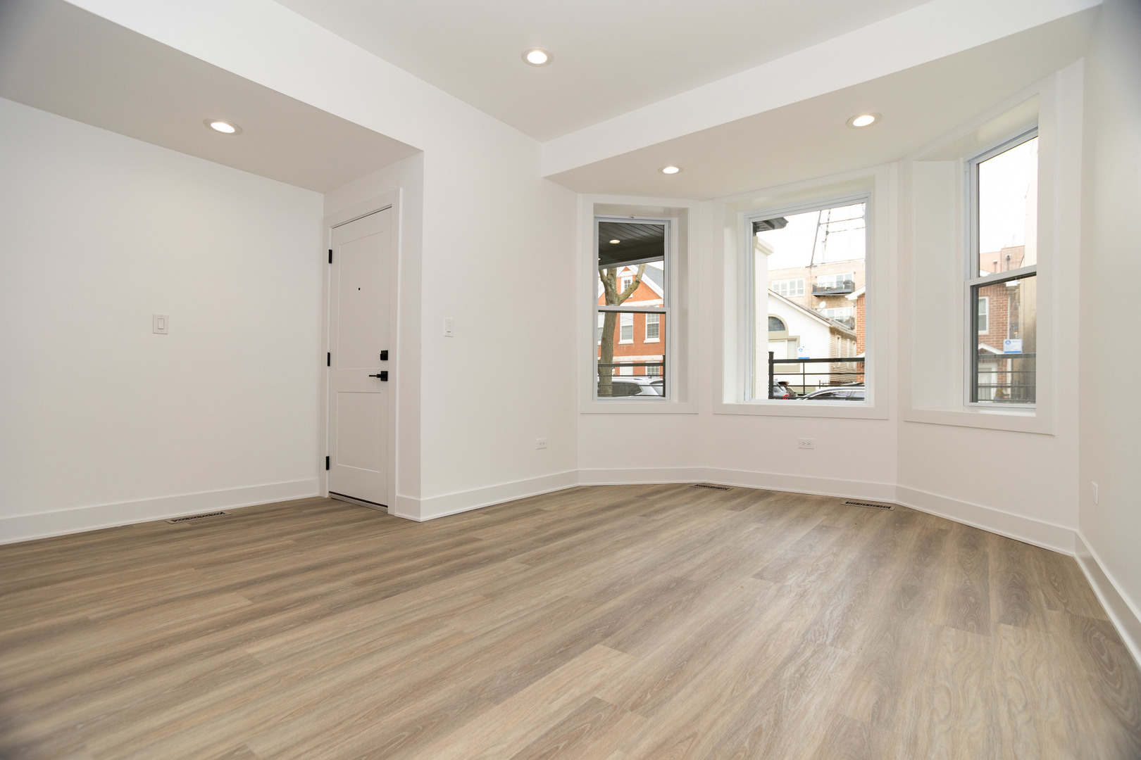 1723 West Pierce Avenue, Unit 1 Chicago, IL 60622 - Photo 4 of 24 an empty room with wooden floor and windows