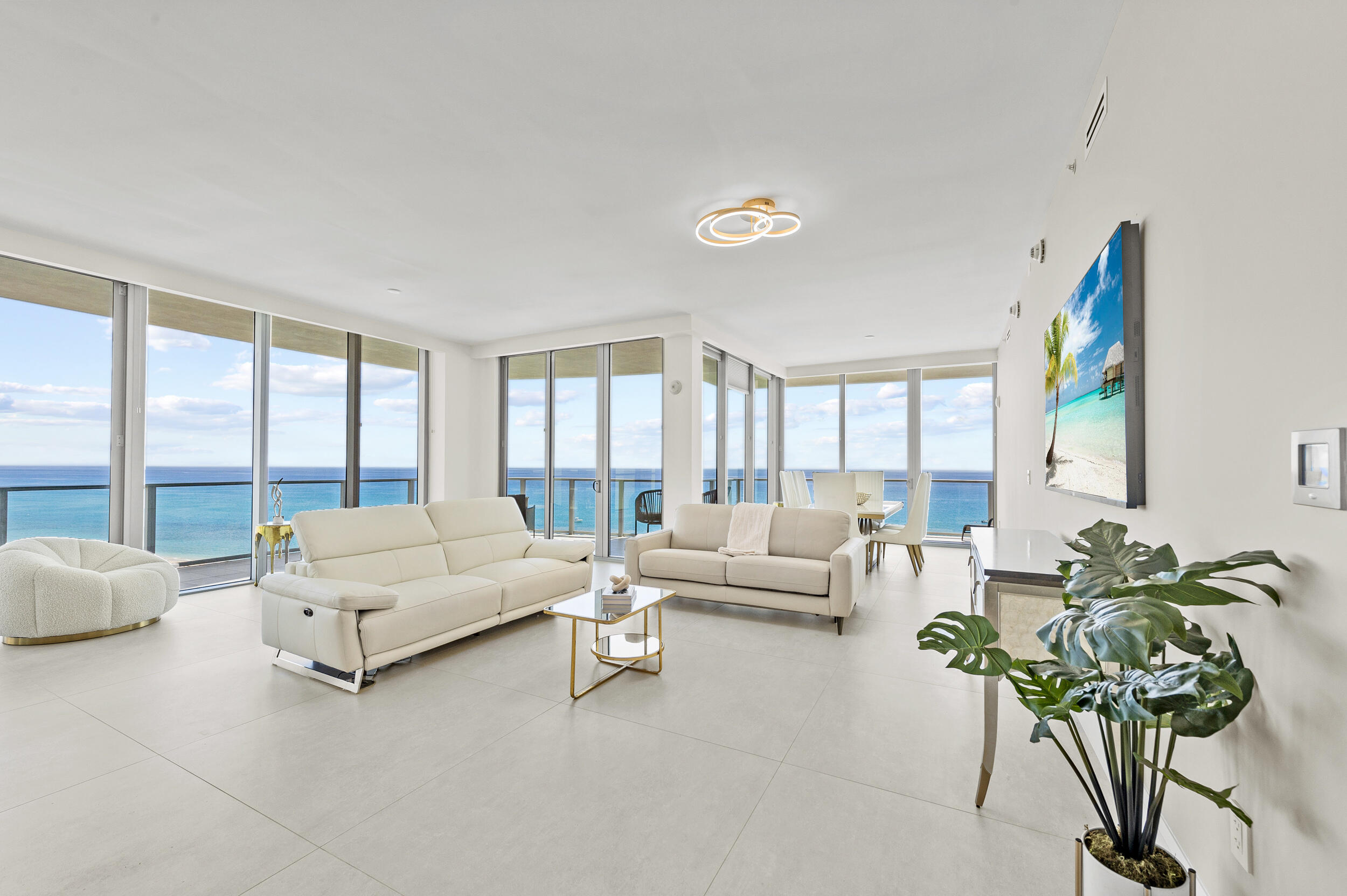 a living room with furniture and a large window with balcony view