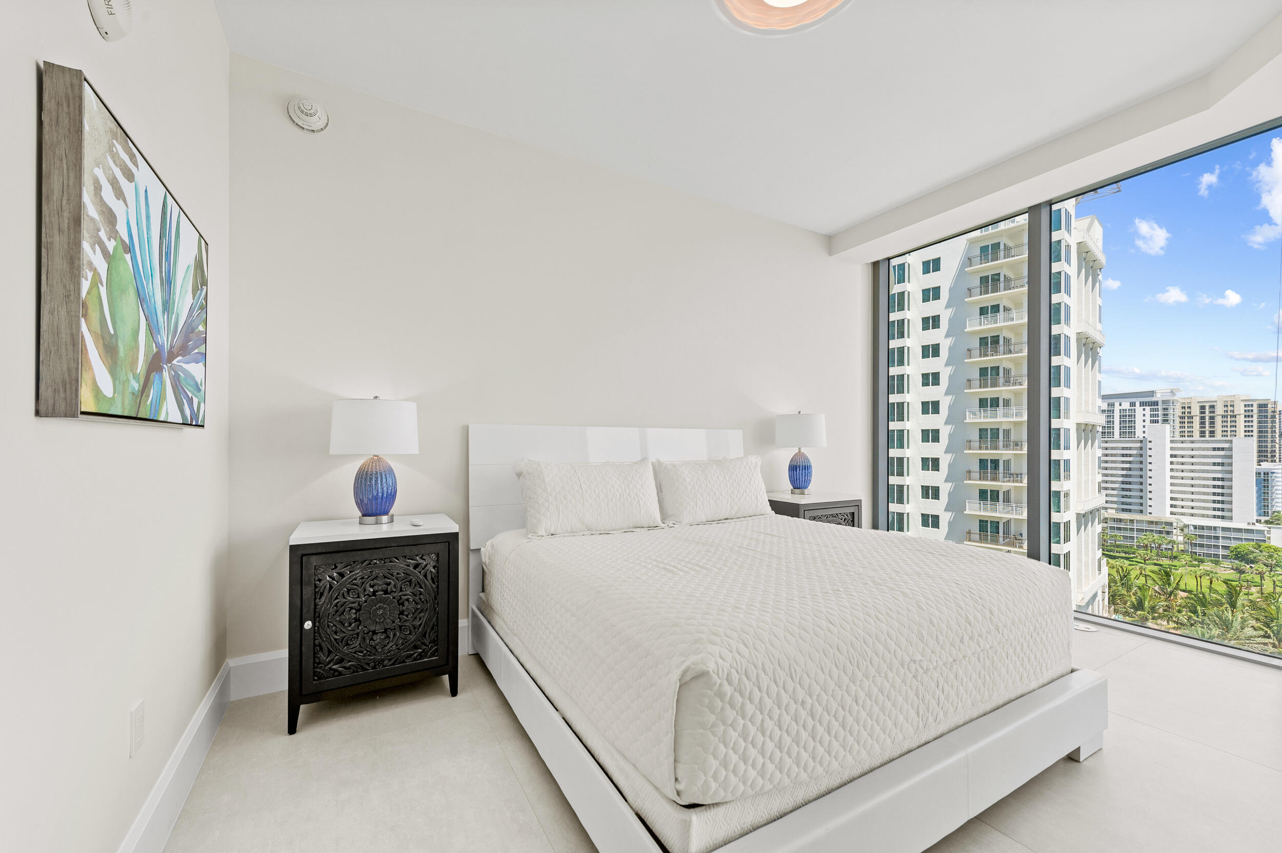 3100 North Ocean Drive, Unit 1103H Riviera Beach, FL 33404 - Photo 25 of 50 a bedroom with a bed table and a large window
