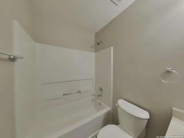 a white toilet sitting next to a bath tub