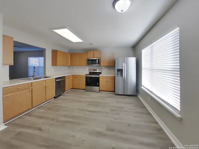 a large kitchen with cabinets and stainless steel appliances