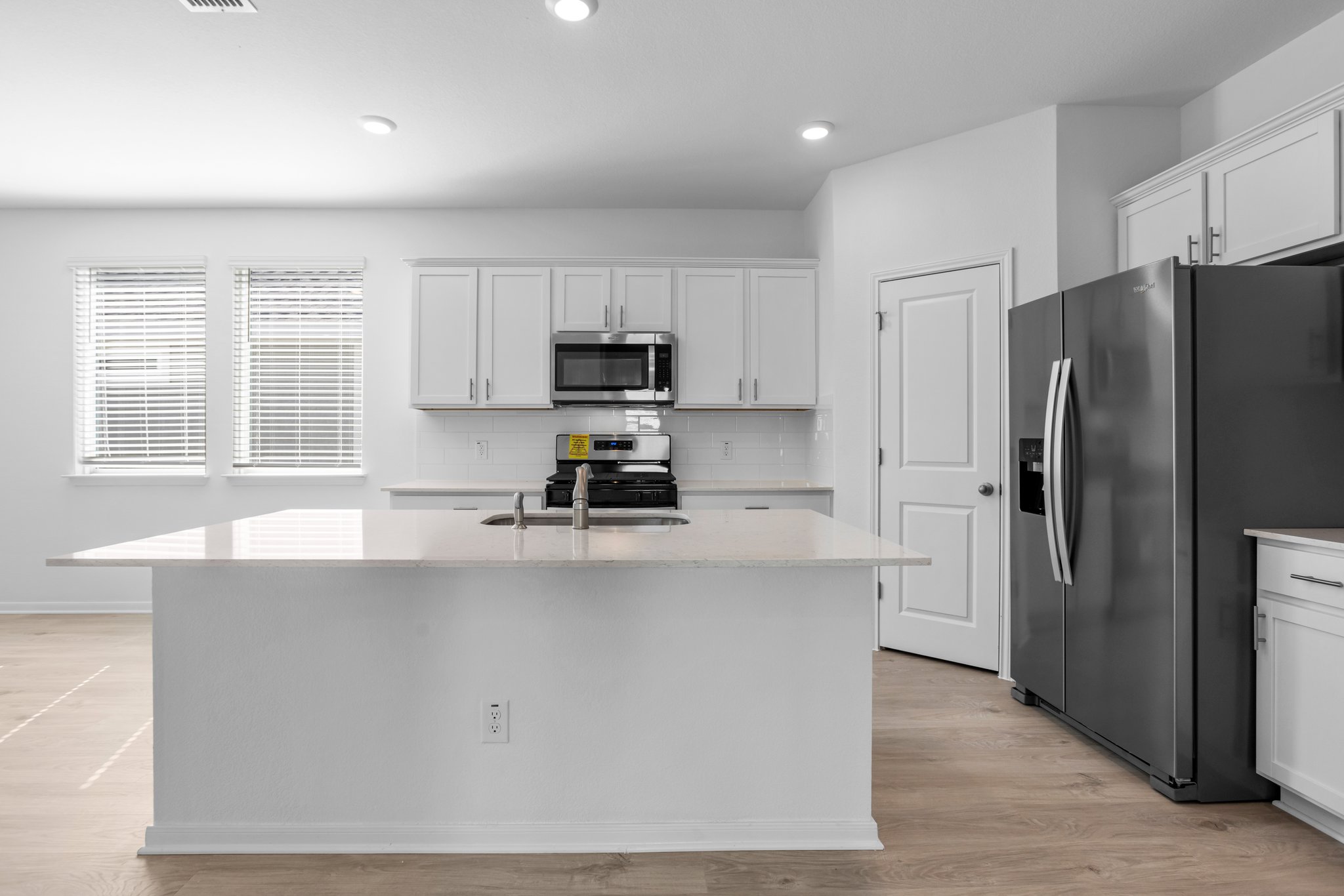 305 Brooks Ranch Drive Kyle, TX 78640 - Photo 10 of 32 a kitchen with kitchen island a counter top space a sink and stainless steel appliances