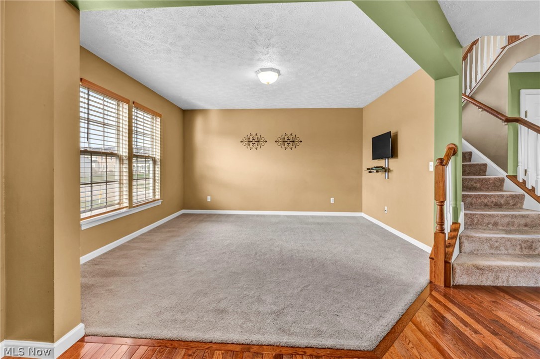 147 Stone Ridge Way Berea, OH 44017 - Photo 4 of 44 Spare room featuring a textured ceiling, light wood finished floors, and light carpet