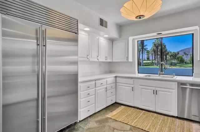 a living room with patio furniture and potted plants