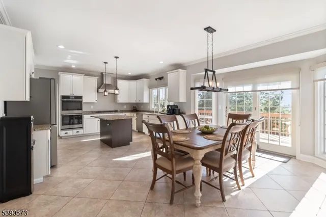 a dining area with a table chairs and a kitchen view