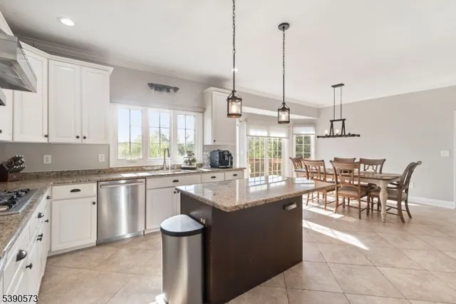 a kitchen with kitchen island granite countertop a sink a counter top space and appliances