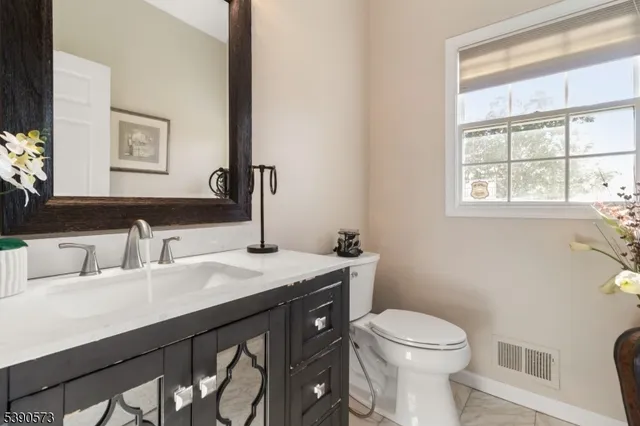 a bathroom with a granite countertop toilet sink and mirror