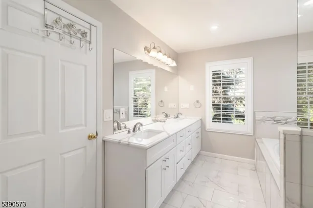 a bathroom with a tub sink and mirror