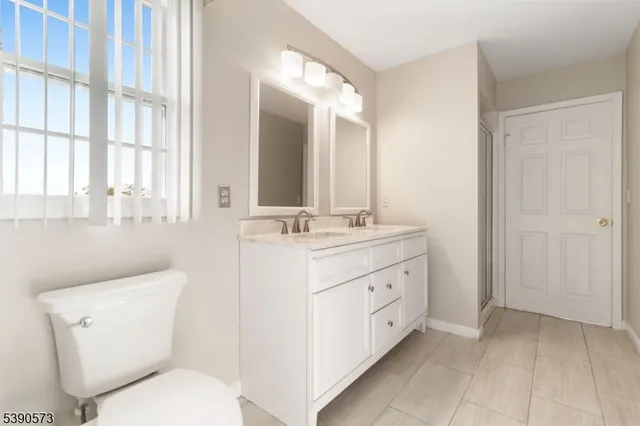 a bathroom with a double vanity sink toilet and a tub