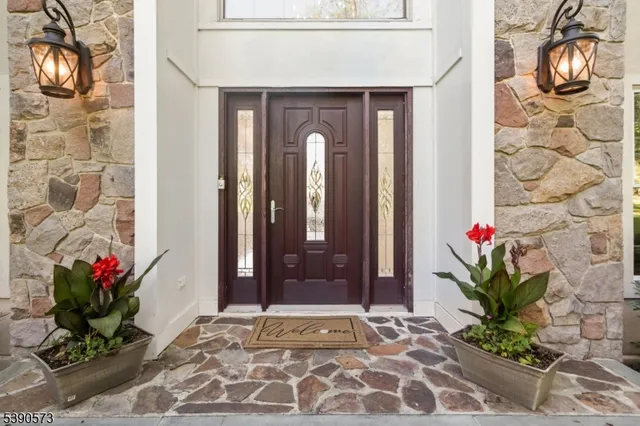 a vase with flowers sitting on a floor in front of a door