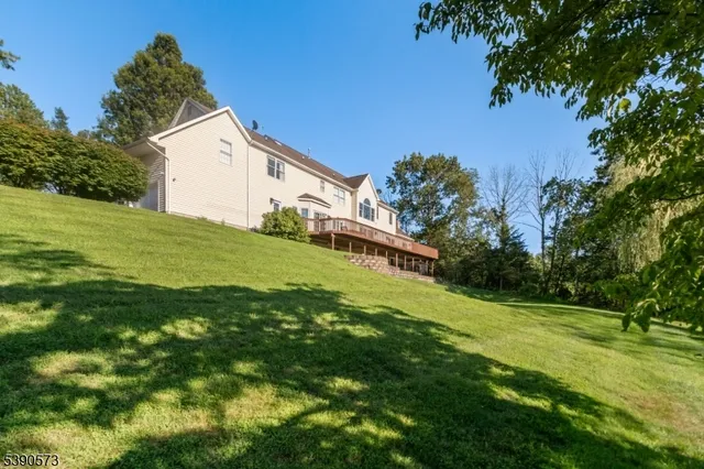 a backyard of a house with plants and large trees