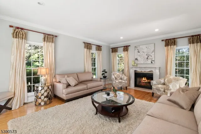 a living room with furniture a fireplace and a large window