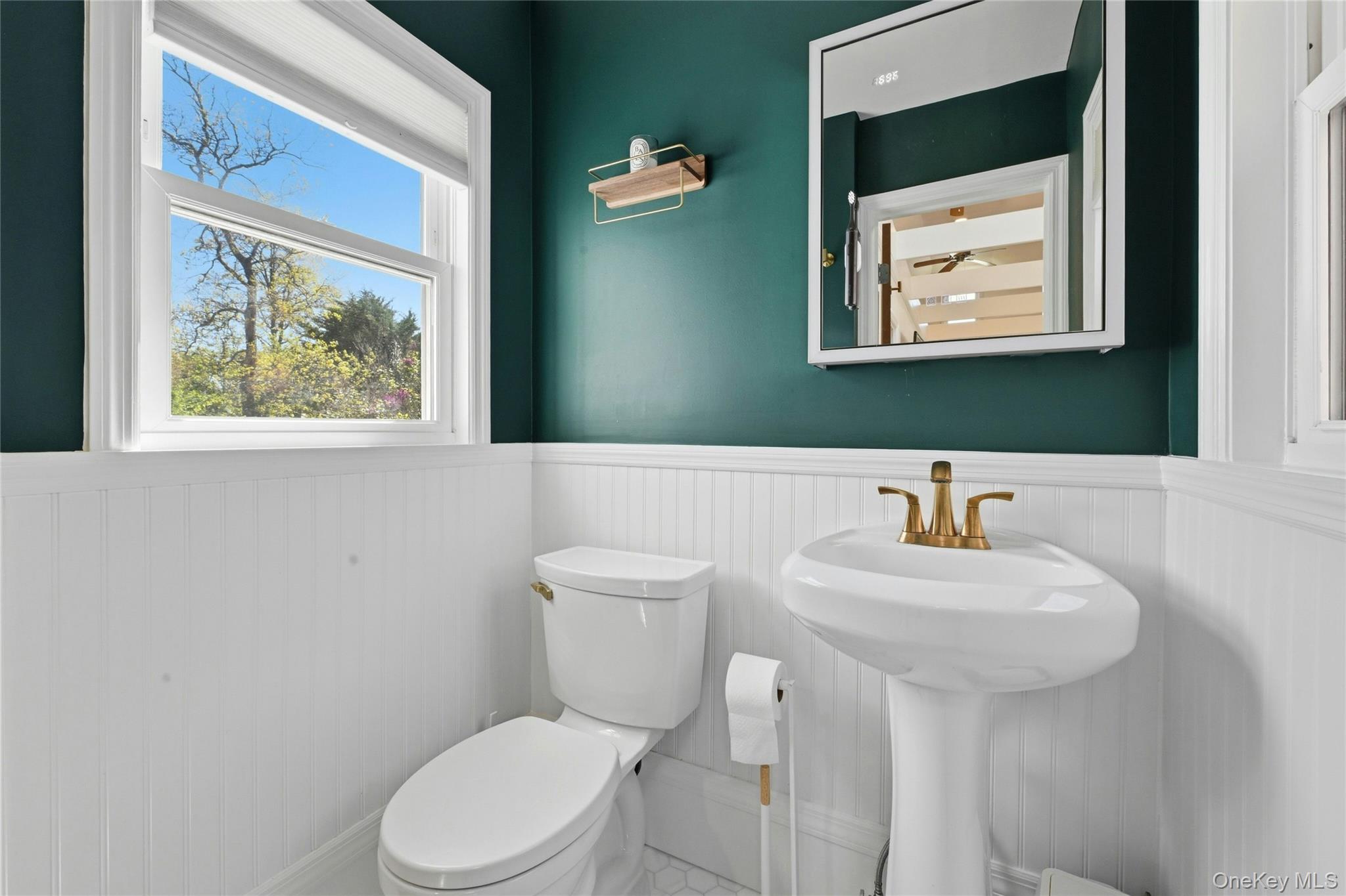 46 Beach Road Laurel, NY 11948 - Photo 13 of 24 a bathroom with a toilet sink and mirror