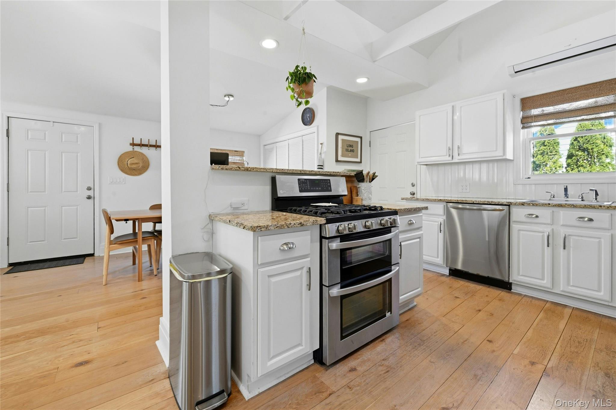 46 Beach Road Laurel, NY 11948 - Photo 7 of 24 a kitchen with stainless steel appliances a stove a sink cabinets and wooden floor