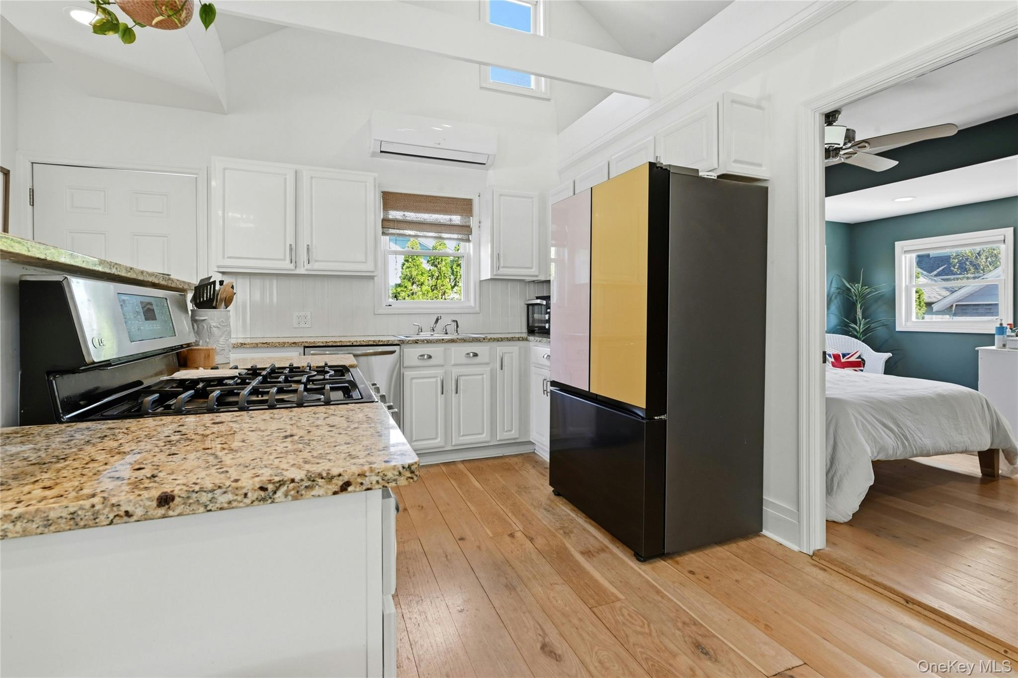 46 Beach Road Laurel, NY 11948 - Photo 8 of 24 a kitchen with a refrigerator a stove top oven a counter space and wooden floor