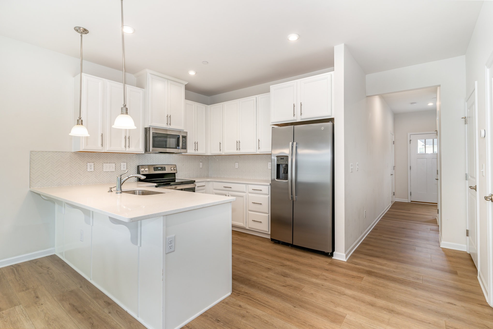 160 Keelon Gap Road Spring Hill, TN 37174 - Photo 5 of 32 a kitchen with stainless steel appliances granite countertop a refrigerator a sink dishwasher a stove and white cabinets with wooden floor