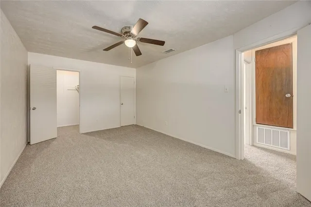 an empty room with closet and windows
