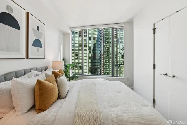 a bedroom with a bed and a large window