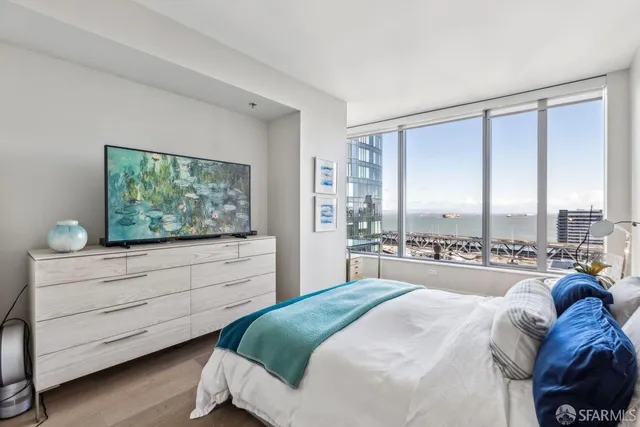 a bedroom with a bed and a large window