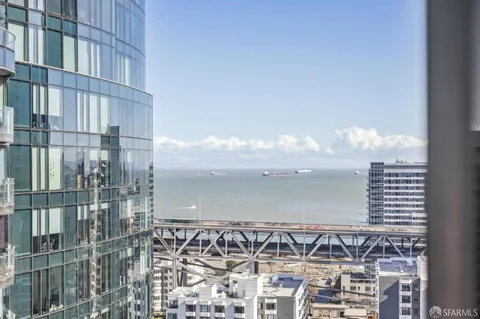 a large kitchen with kitchen island a large window a sink and stainless steel appliances