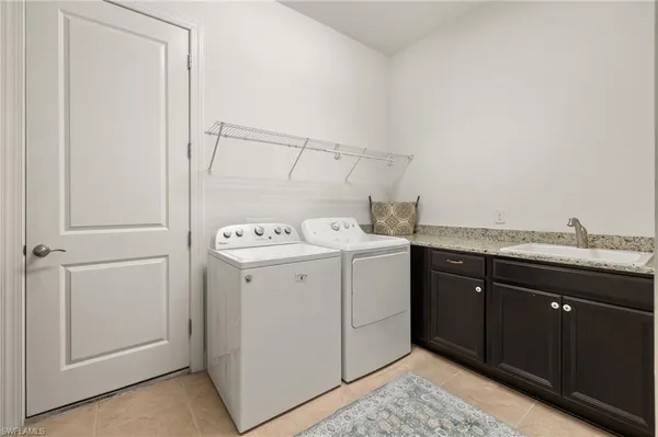 a utility room with cabinets washer and dryer