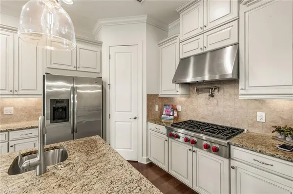 a kitchen with stainless steel appliances granite countertop a stove a refrigerator and cabinets